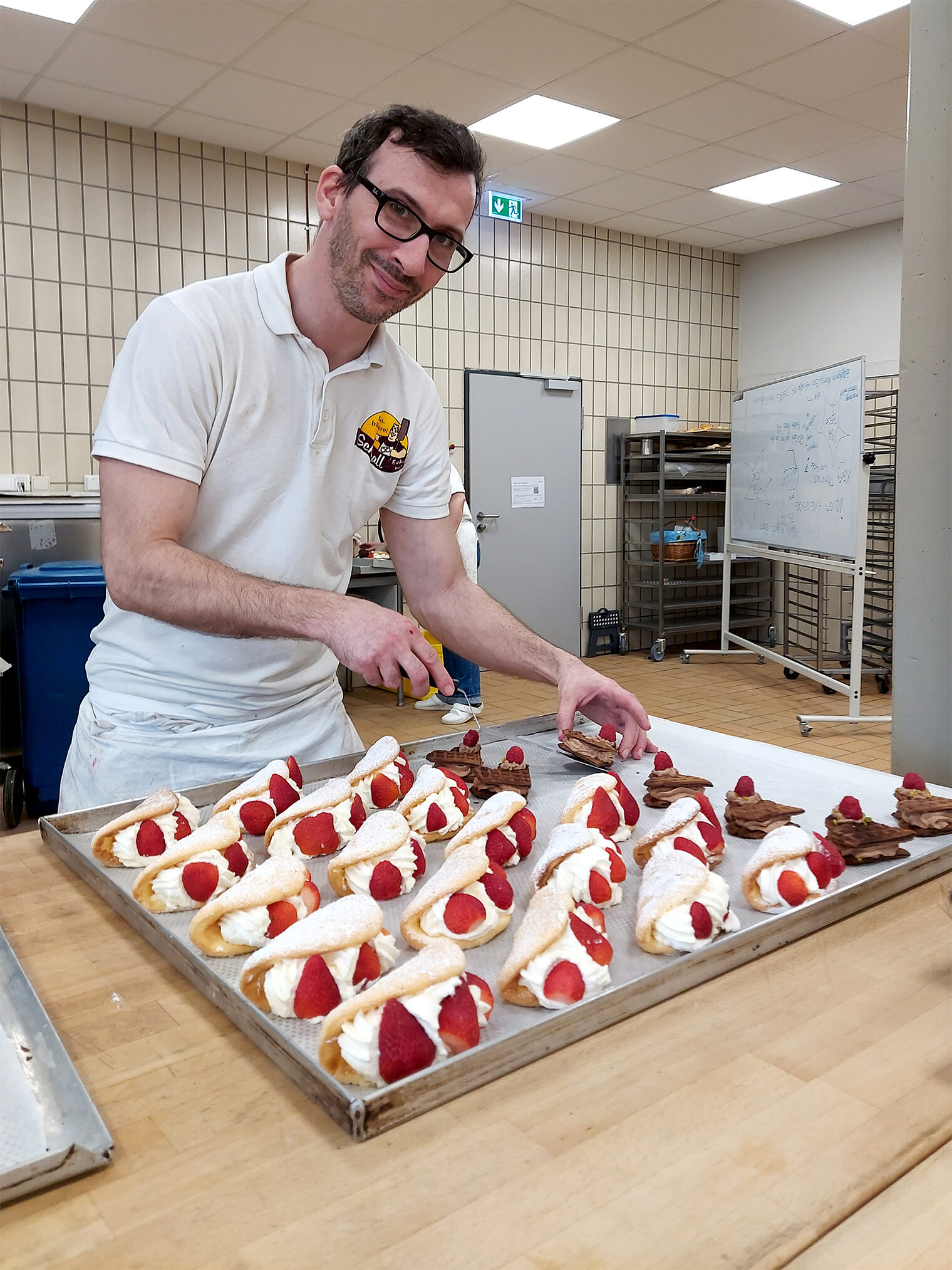 Meisterschule Bäcker - Bäckermeisterkurs Person platziert Desserts auf einem Tablett