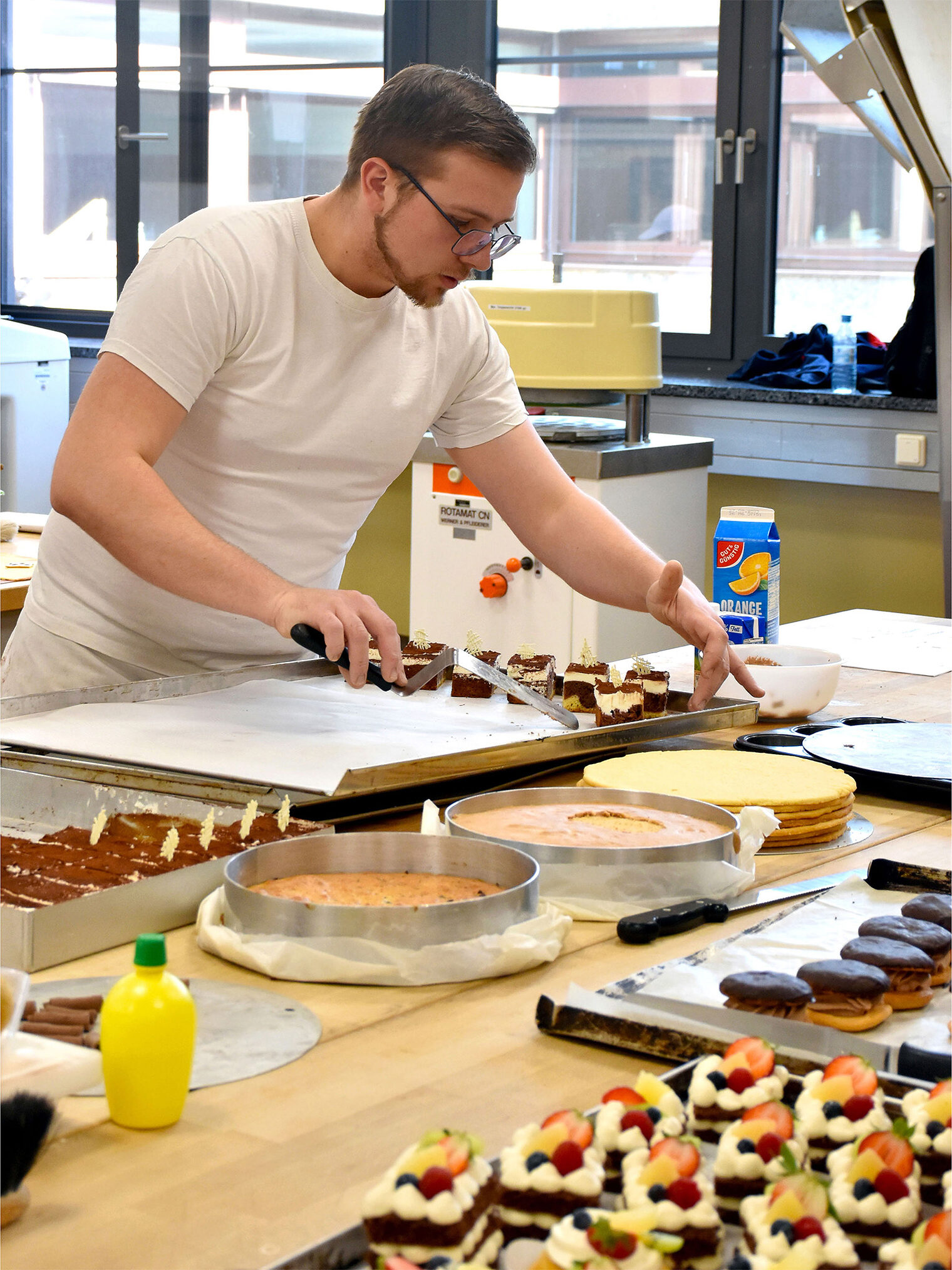 Meisterschule Bäcker - Bäckermeisterkurs Person platziert Desserts auf einem Tablett